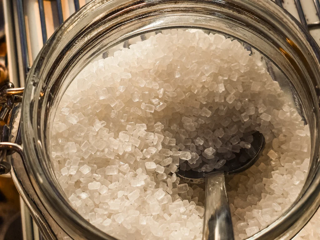 Close-up view of coarse white sugar crystals, illustrating how crystalline sugar appears
